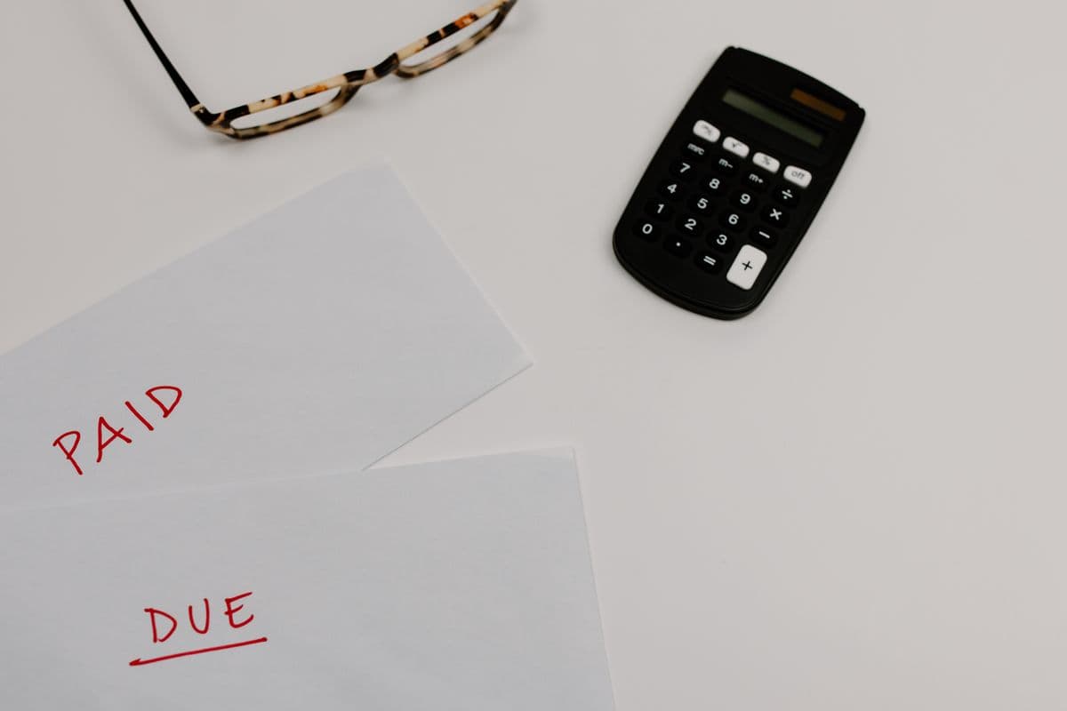 Financial papers labeled paid and due beside a calculator