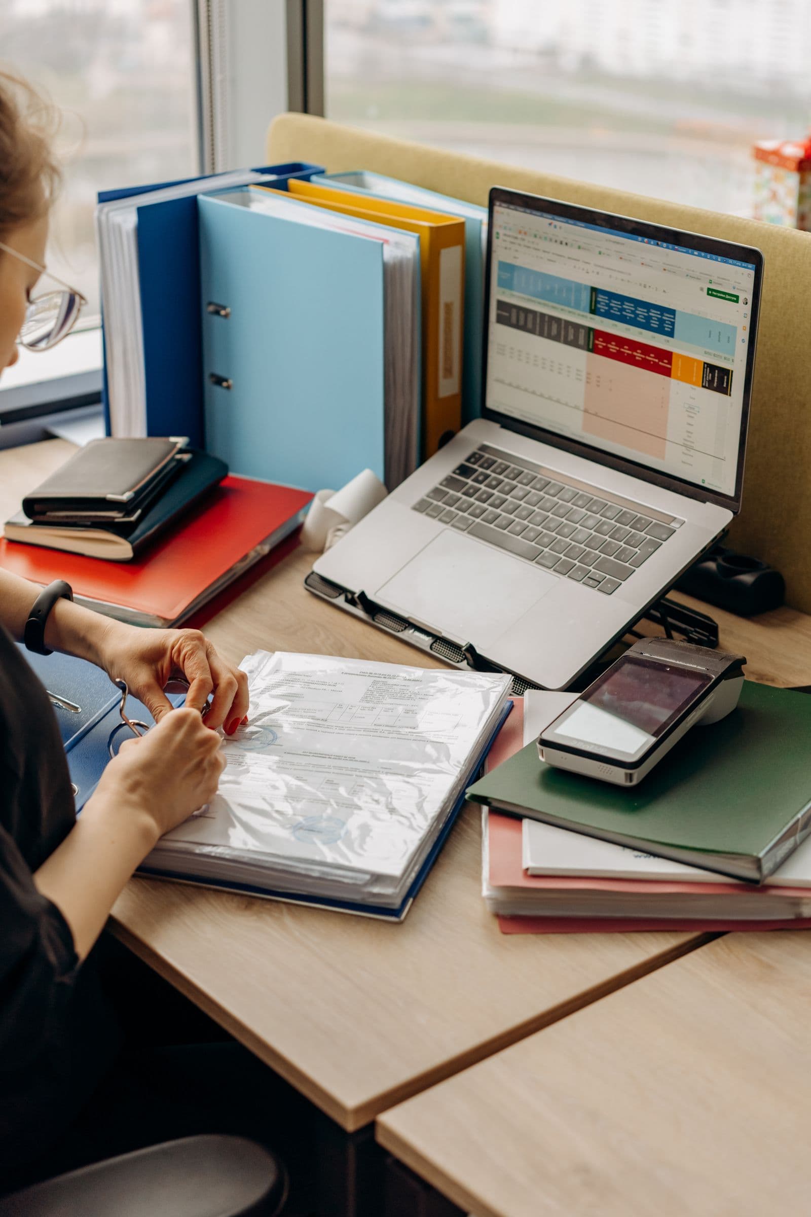Administrator organizing documents and files at a desk