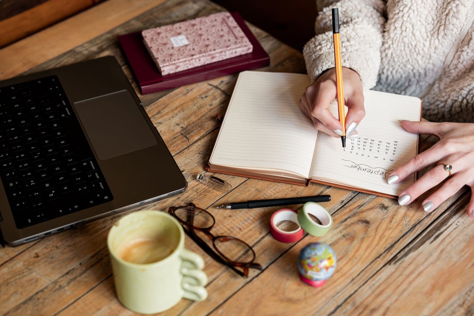 Copywriter drafting content on a laptop with notes nearby