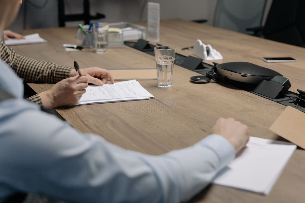 Business meeting with individuals signing documents at a conference table