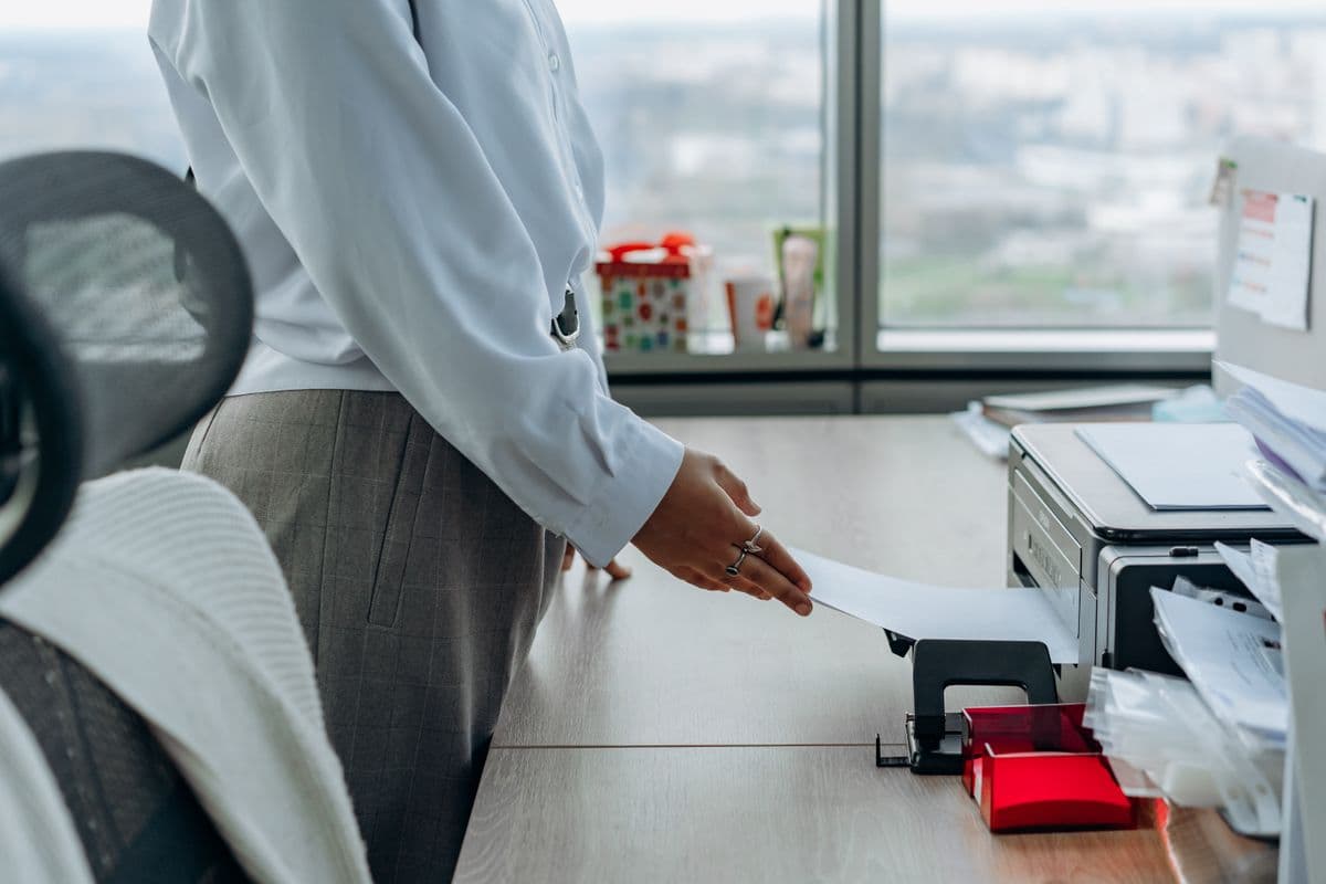 Business professional printing a document in an office