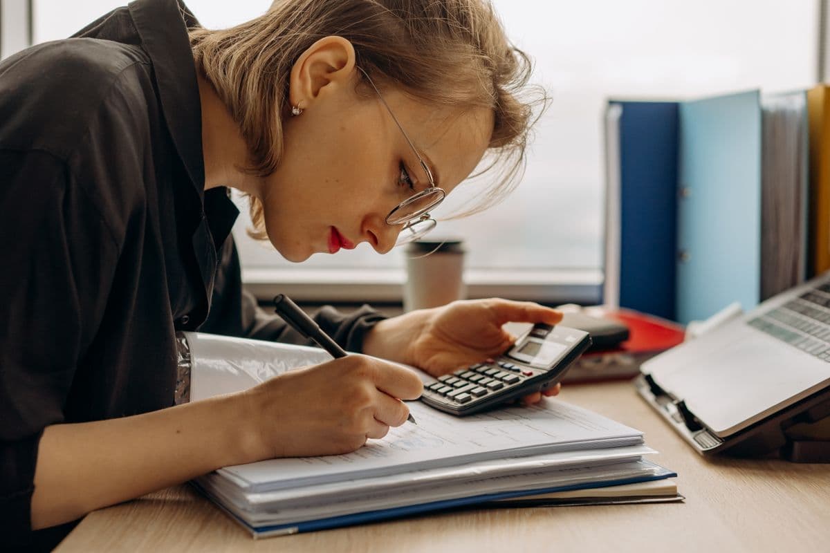 Accountant diligently working on close with a calculator and documents