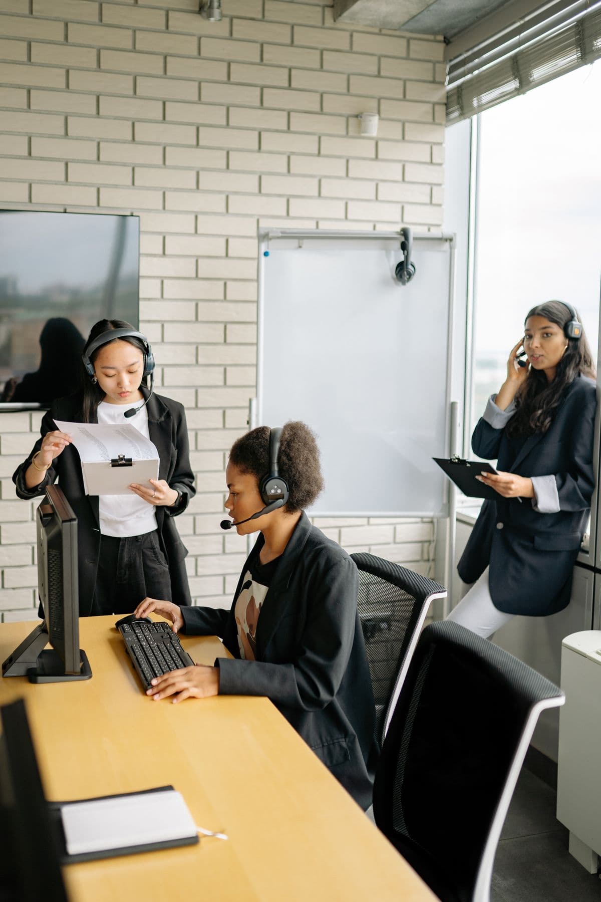 Three call center agents with headsets working together in an office