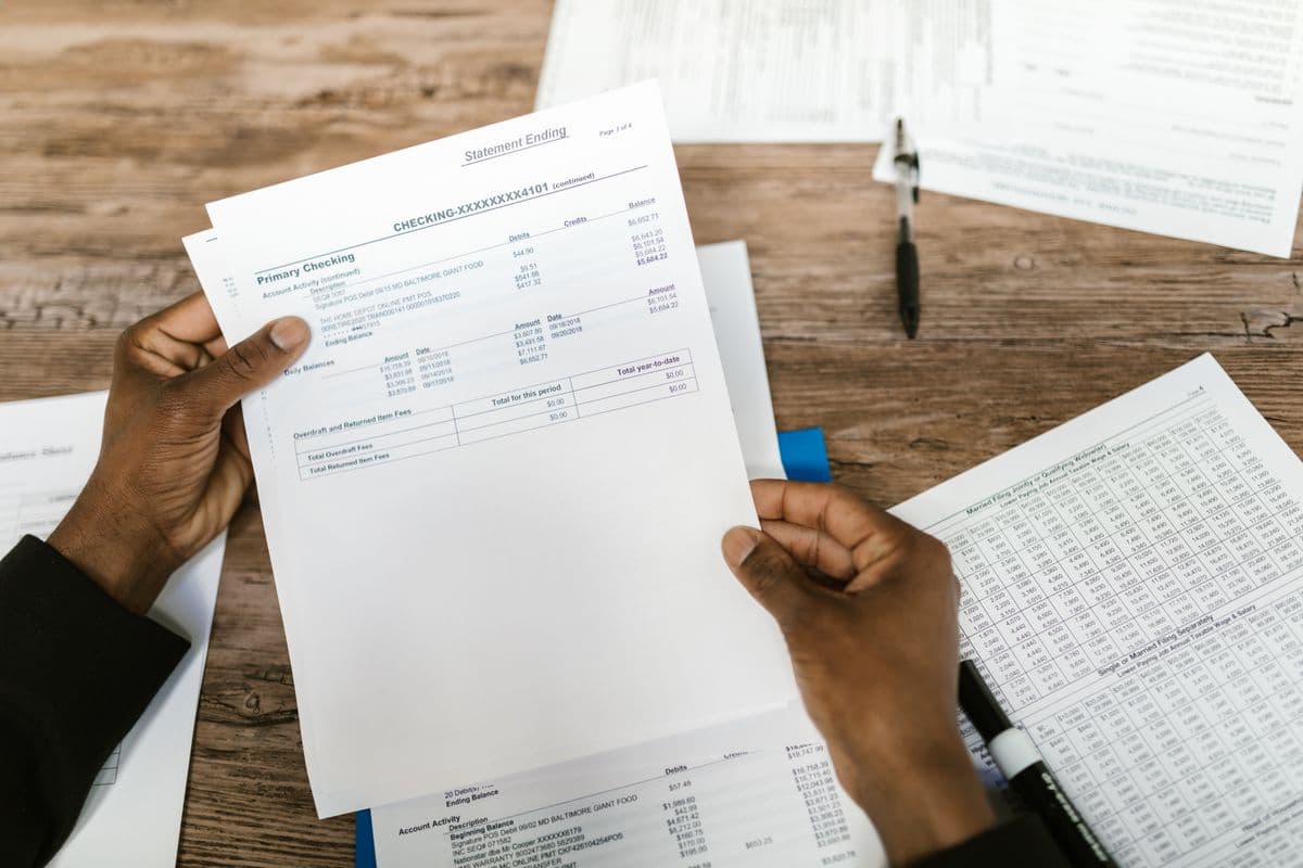 Hands holding financial papers for reconciliation and analysis