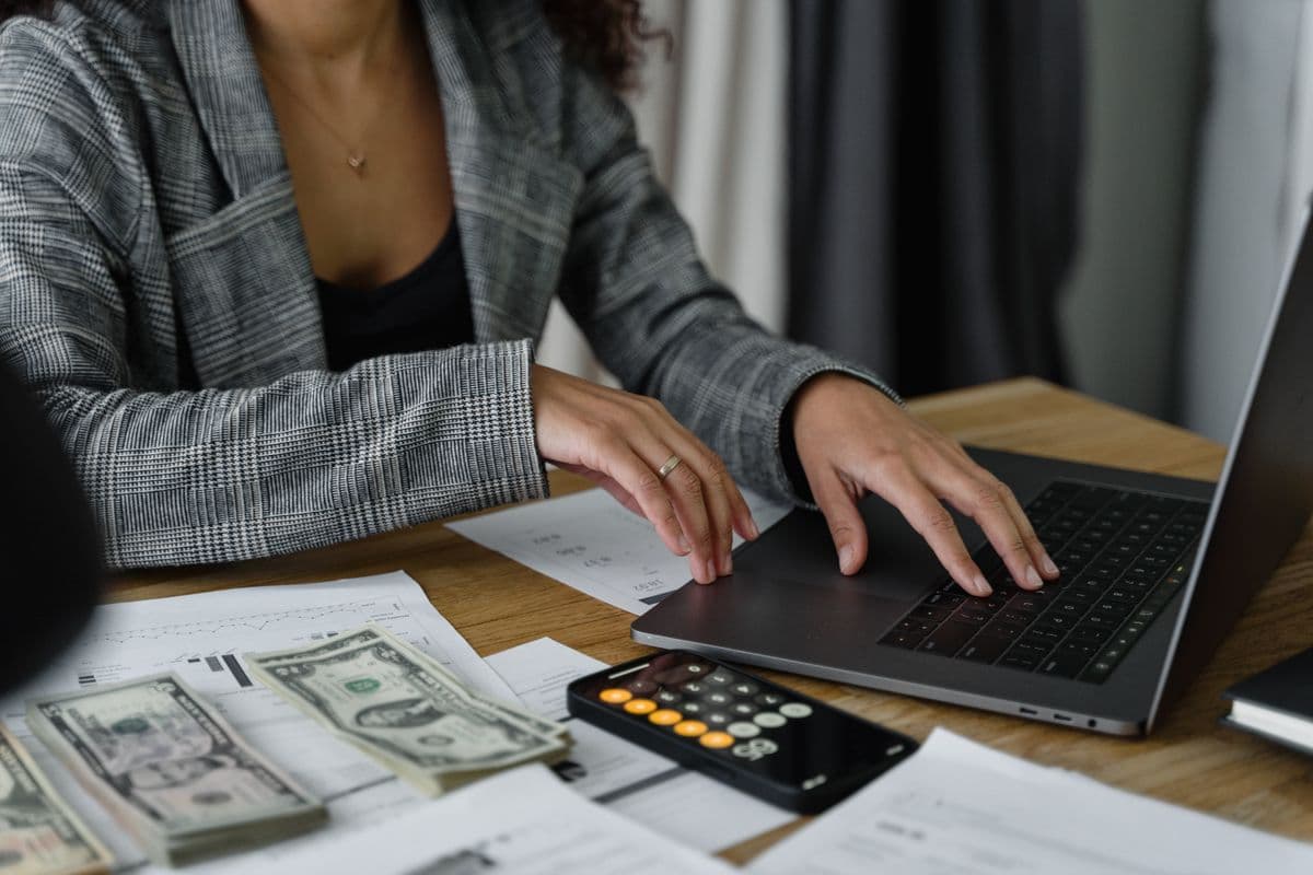 Finance professional managing payroll with cash and calculator