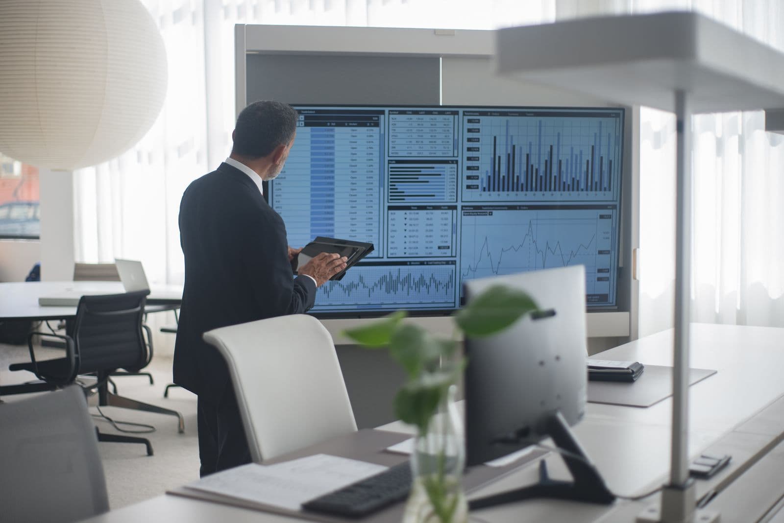 Financial analyst reviewing data on multiple screens