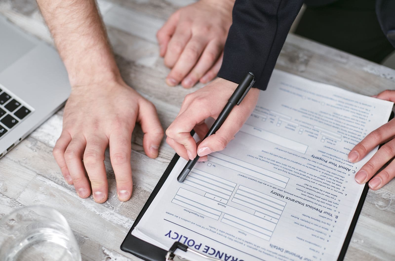 Two people signing a new insurance policy document
