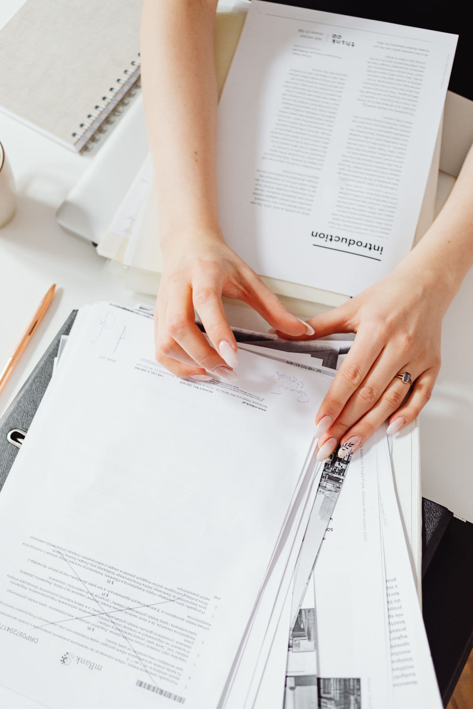 Hands organizing policy paperwork on a desk
